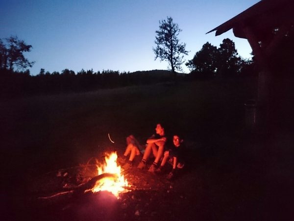 Sitting around the fire at dusk.